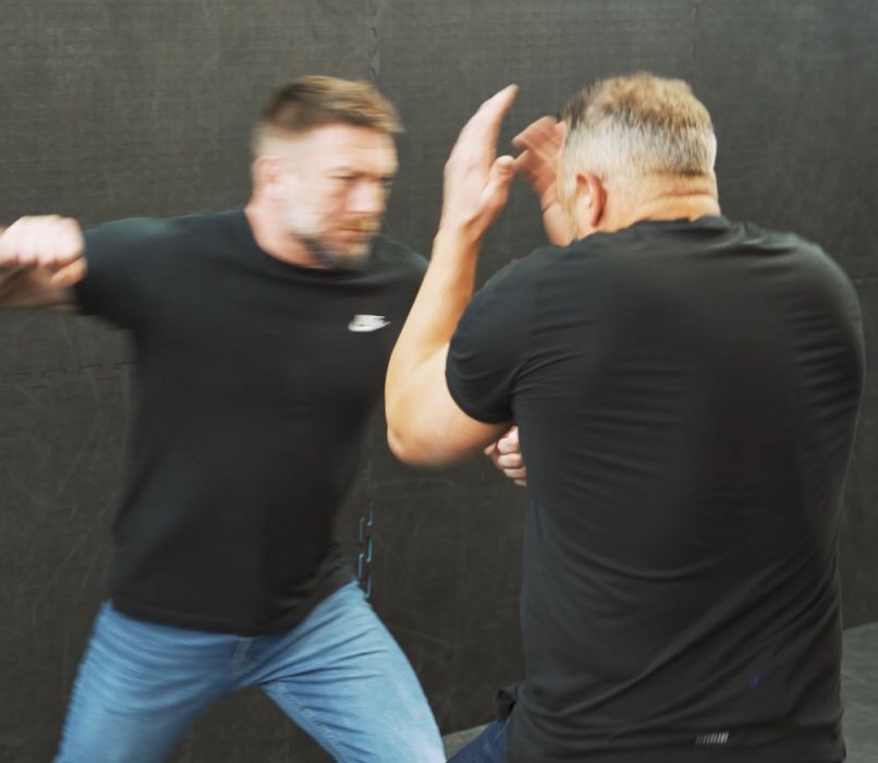 Adam blocking a punch and striking back in the training room